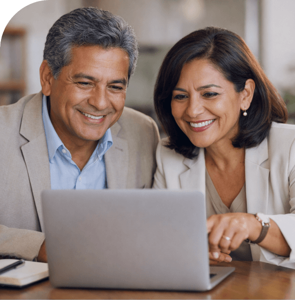 Pareja usando una laptop y sonriendo